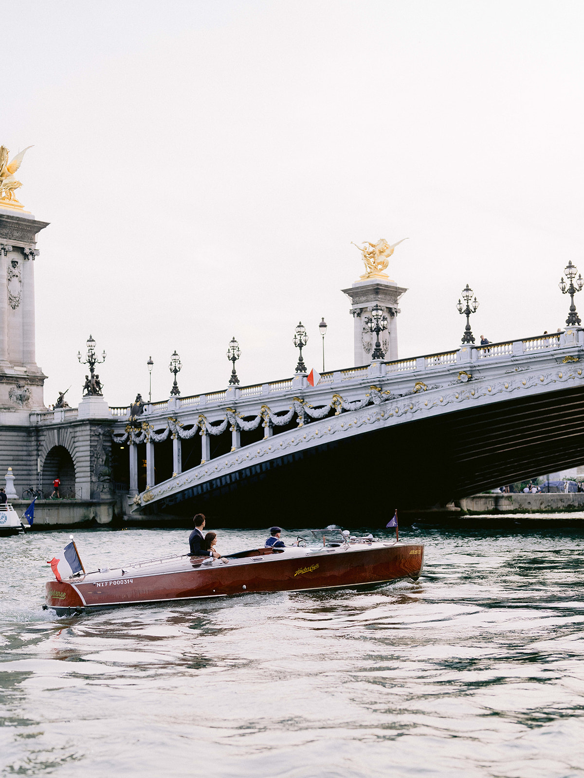 Private boat passing Pont Alexandre III during a Paris engagement photo session